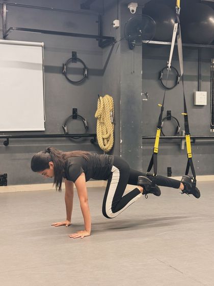 A TRX-assisted mountain climber, a challenging variation that requires significant core strength and stability. I love finding new ways to push my own limits.