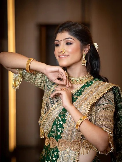 This shot highlights the beautiful details of her blouse and the traditional gold belt, with the makeup providing a soft, glowing frame for her face.