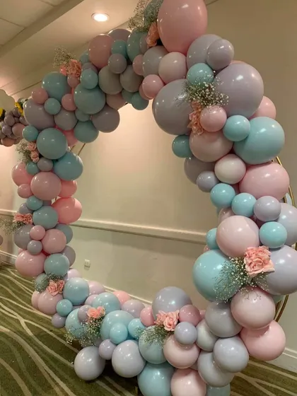 This shows our softer, more delicate design style, perfect for baby showers, christenings, or elegant birthdays. The organic balloon ring uses a pastel palette of blue, pink, and lavender, accented with fresh baby's breath and roses for a touch of romance.