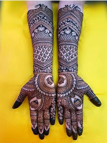 This full-hand design showcases a mix of popular traditional elements. It includes checkerboard patterns, floral bands, and a central circular motif for a classic bridal style.