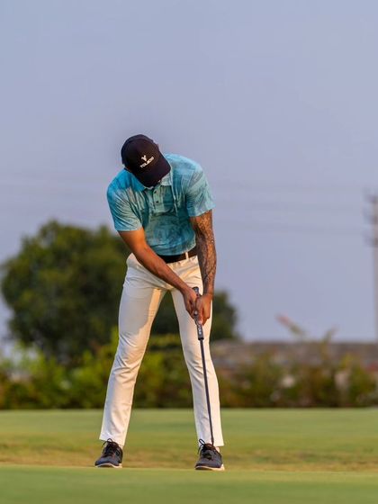 A front-on view of a golfer's putting stance. Our coaches work on establishing a stable and repeatable setup for greater consistency.
