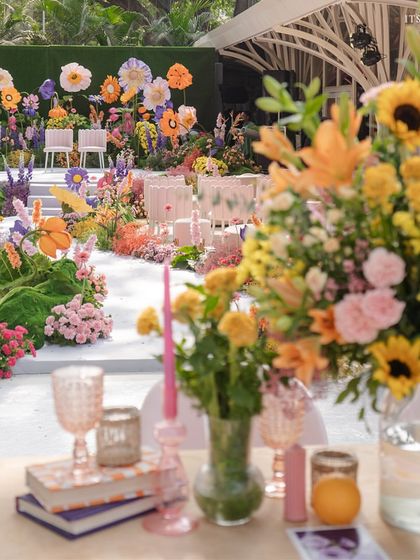 A glimpse of the 'A Blooming Day' wedding ceremony, where a vibrant, surreal garden of giant flowers creates an unforgettable backdrop.
