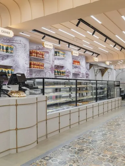 The main counter at Sangam Sweets, where a rich history of Indian architecture is reinterpreted. The design uses elements like columns, arches, and geometric patterns to create a modern space with deep cultural roots.