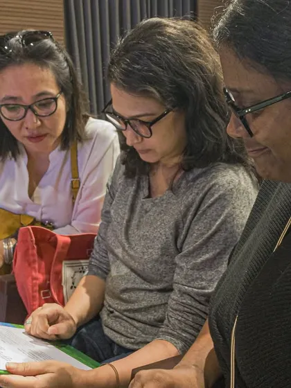 Participants in a workshop collaborating and reviewing notes together.