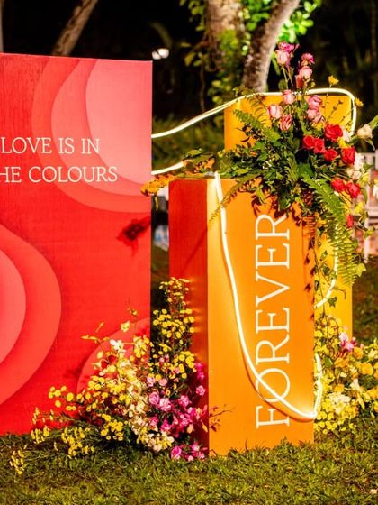A close-up of the custom-printed blocks with phrases like "Love is in the colours" and "Forever," surrounded by fresh flowers.