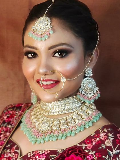 A smiling bride wearing a mint and pink Polki set. This is a fresh and modern color combination for today's bride.