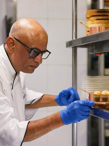 Chef at the pass, inspecting and finishing dishes before they go out to our guests. This final check ensures every plate is perfect.