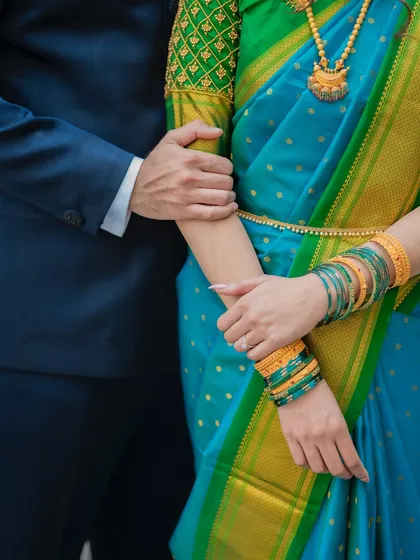 A detail shot focusing on the bride's stunning blouse, jewelry, and the way the groom holds her arm. These shots highlight the beautiful details of the day.