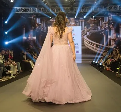The back view of the Muave Pink hand-embellished ball gown as it graced the runway. The flowing train and delicate details are fit for a modern-day bride.