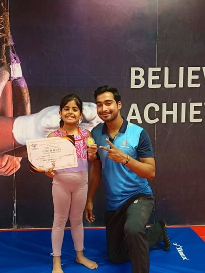A victory pose from this student who just received her medal and certificate.