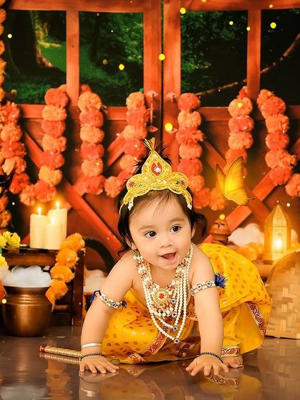 Another adorable little Krishna ready to steal some butter. The warm, festive lighting and marigold garlands make this theme a favorite.