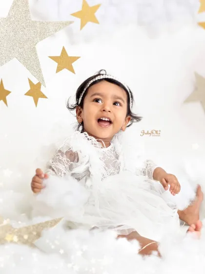 Looking up at the sparkling stars with so much wonder. Her white lace dress makes her look like a little angel.