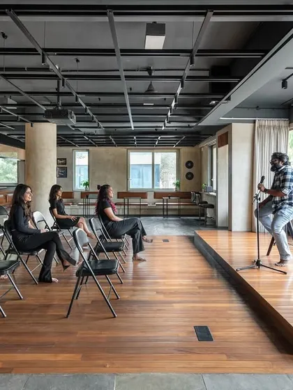 The central zone of our 'Chasing Tales' project was conceived as a versatile stage for community engagement. Here, it is configured for a live performance, demonstrating the space's capacity to transform from a co-working area into a vibrant venue for cultural events.