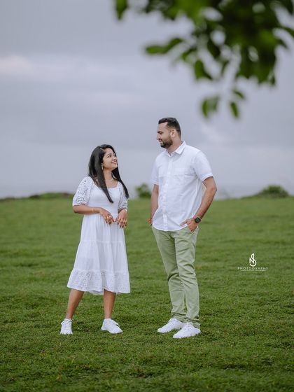 A quiet, standing pose framed by a tree branch, adding a natural element to the composition.