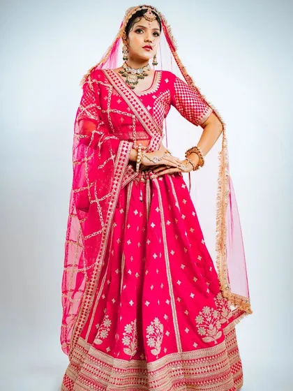 For the bride who loves a pop of color, this vibrant pink Marvadi-style lehenga is a beautiful choice. The full skirt and detailed craftsmanship ensure you look and feel spectacular.