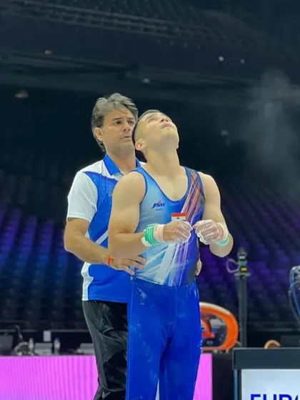 A final word of encouragement before a still rings routine at the World Championships. These moments of connection and focus are vital for a successful performance.