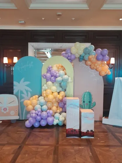 A full view of the stylish "Babychella" baby shower backdrop, combining pastel arched panels with a flowing balloon garland for a modern and chic celebration.