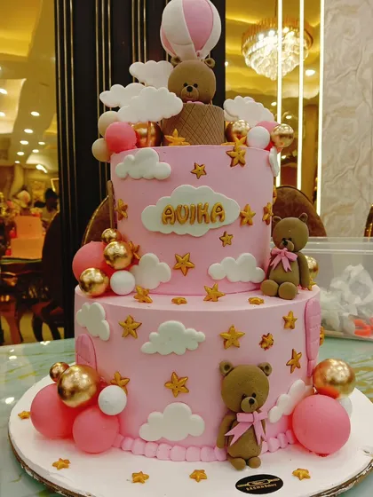 A dreamy two-tier cake for a special birthday, featuring adorable teddy bears, a hot air balloon, and fluffy clouds. We love working on detailed themes like this to create a centerpiece that tells a story.