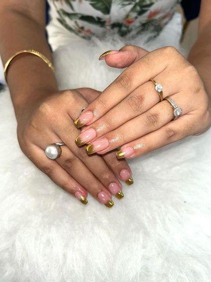 A glamorous French manicure with a sparkling gold chrome tip.