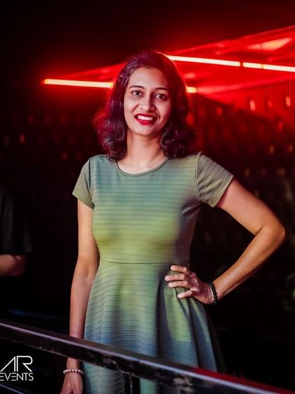 A guest posing against the red neon lights of the club.