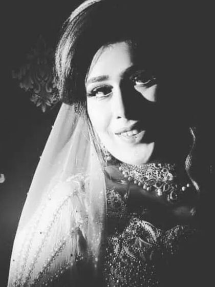 A dramatic black and white bridal portrait with strong side lighting. This creates a high-contrast, moody image that is both artistic and powerful, highlighting the bride's confident expression.