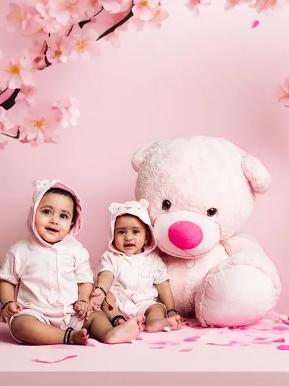 An AI-enhanced version of our twin photoshoot. We placed these adorable babies in a magical pink landscape with cherry blossoms, creating a fantasy portrait.