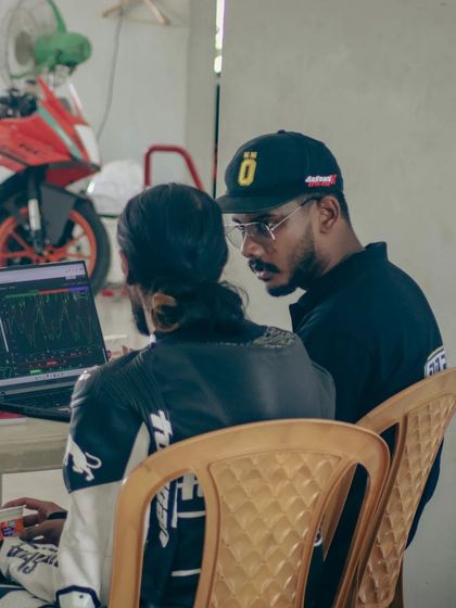 Two riders discussing their session while looking at telemetry data. Peer learning is a powerful tool that we encourage at our school.