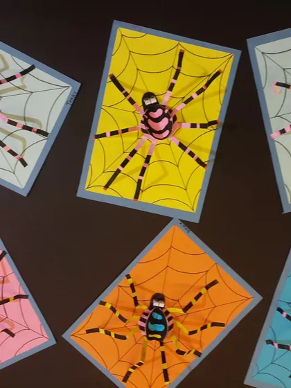 A collection of colorful 3D paper spiders. This project teaches basic paper sculpture techniques and lets students play with bold color combinations.