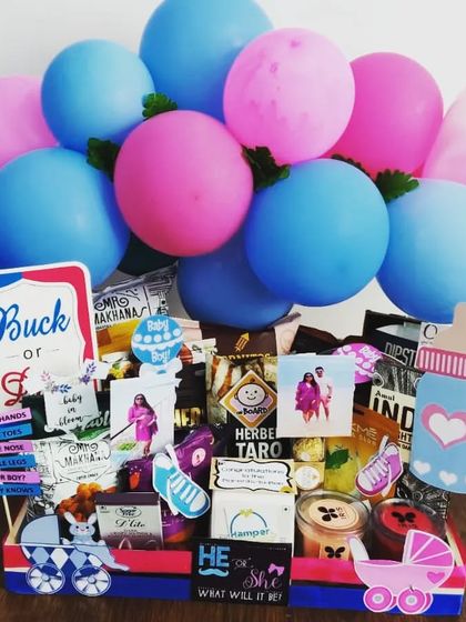Buck or Doe? This gender reveal hamper is filled with snacks and decorated with pink and blue balloons and signs. It's a fun way to build excitement for the big reveal.