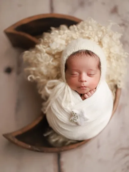 Little moon and star. Another take on the celestial theme, with the baby wrapped in white and nestled in a wooden moon prop.
