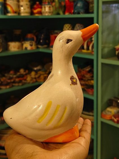 A finished, hand painted duck figurine, showcasing the kind of charming and personal artwork you can create and take home.