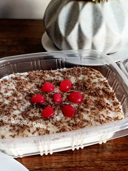 A single portion of my Mixed Fruit Soufflé, topped with chocolate shavings and bright red cherries in a clear container.