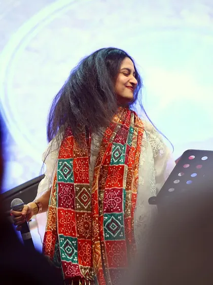 A smiling shot of me on stage, wearing a traditional Gujarati scarf for a Garba night. I love to embrace the local culture in my performances.
