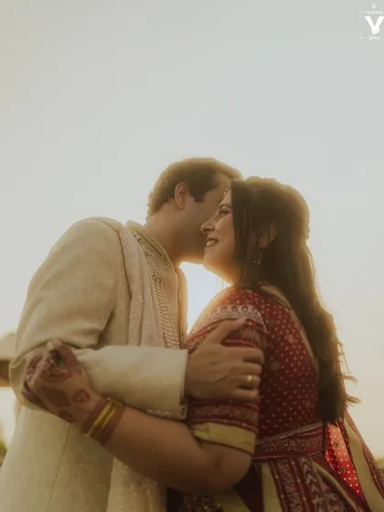 A golden hour embrace, with the sun creating a beautiful flare behind the couple. This warm and romantic shot perfectly captures the magic of their love.