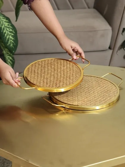 Our round woven trays with gold handles, available in two sizes. These trays are perfect for serving drinks or as a decorative base for a centerpiece on your coffee table.