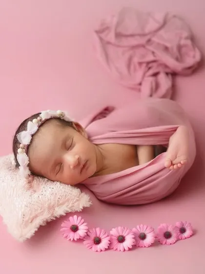 The most gorgeous little girl. This classic "potato sack" wrap pose is perfect for keeping newborns snug and sleepy, and the simple pink theme is always a favorite.