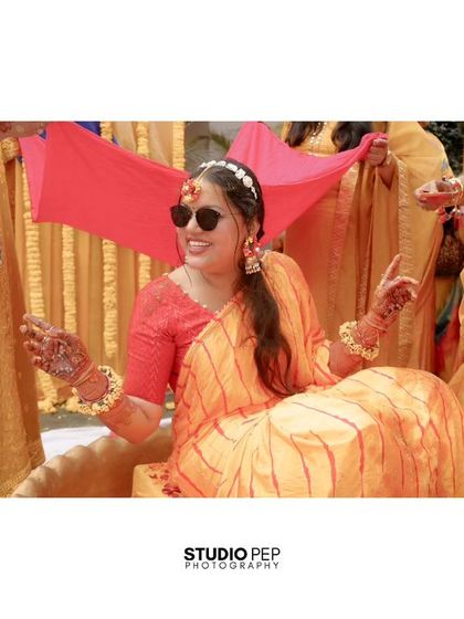 The bride makes a cool entrance, wearing sunglasses and being escorted under a pink canopy held by her bridesmaids.
