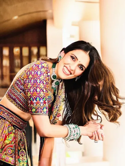 A happy, candid shot that shows off the beautiful colors and detailed blouse of this designer lehenga. It’s perfect for a mehendi or sangeet ceremony.