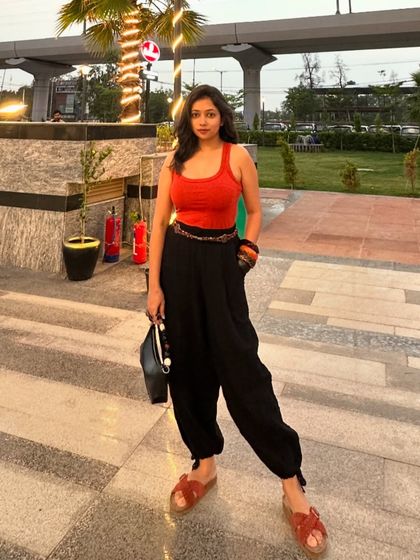 A full-length shot of the orange and black outfit. The relaxed fit of the pants makes it a comfortable yet stylish choice.