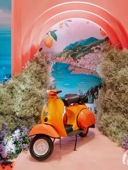 We believe in adding playful, personal touches, like this vintage orange Vespa set against a hand-painted Amalfi Coast backdrop. This custom photo booth became a memorable highlight of the 'La Dolce Vita' themed engagement party.