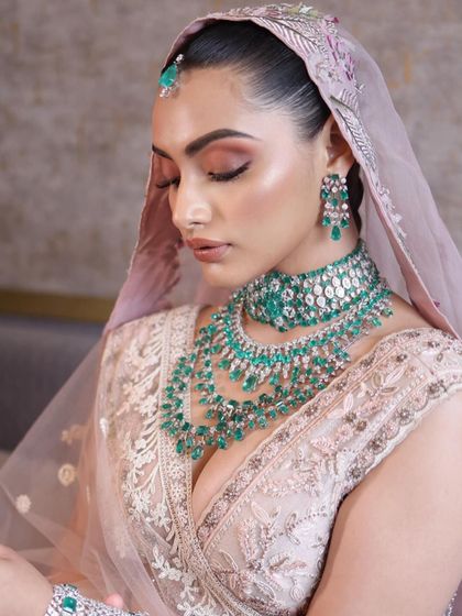 The beauty of a pastel bridal look lies in its subtlety. Here, I've used soft pinks and a luminous highlight to create a fresh, dewy look that complements the delicate embroidery and emerald jewellery.