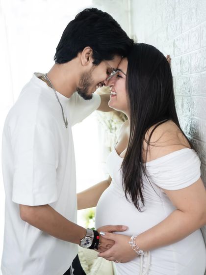 An intimate and joyful black and white portrait. This couple shares a laugh while leaning against a wall, creating a candid and heartwarming image.
