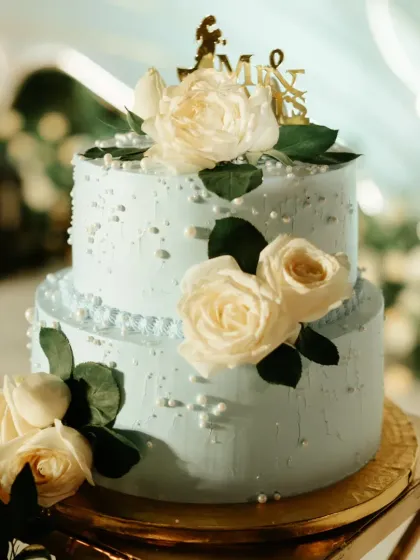 An elegant two-tier wedding reception cake in a lovely pastel blue. I decorated it with fresh white roses and delicate sugar pearls for a timeless and romantic look. I can coordinate with your florist to match the flowers on your cake to your wedding bouquet.