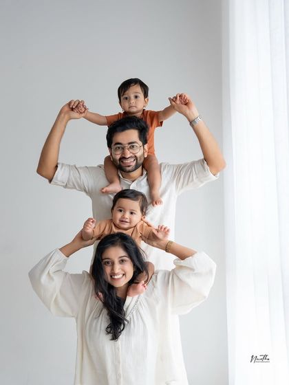 A fun and creative family portrait, with both kids getting a shoulder ride from mom and dad.