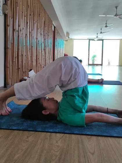 A student holds Halasana (Plough Pose) with precision in our studio. This inversion stretches the shoulders and spine, stimulates the abdominal organs, and has a deeply calming effect.