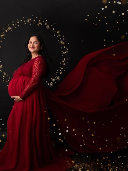 A magical portrait in a flowing red gown. The sparkling golden halo and bokeh effect create a festive and celebratory feel, perfect for this joyous time.