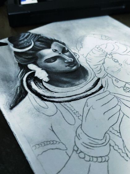 An angled view of the Shiva and Parvati drawing in progress, showing the tools of the trade alongside the developing artwork.