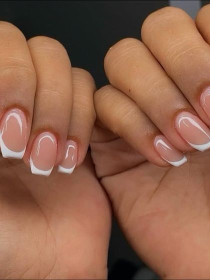 Timeless elegance with a classic French tip. This picture showcases a perfectly executed, clean, and glossy French manicure on beautifully shaped square nails.