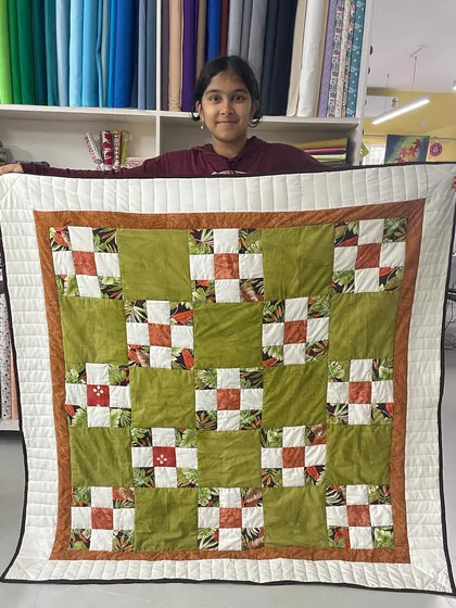 It’s a joy to see our youngest creators shine. Here, 12-year-old Shresta proudly displays her very first quilt, a beautiful patchwork project she completed in our kids' sewing workshop.
