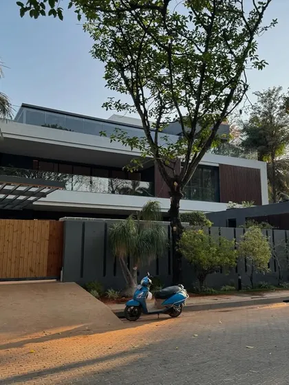 A daytime view of a modern Bangalore residence, showing the clean lines, cantilevered structures, and a mix of materials that define our contemporary architectural style.